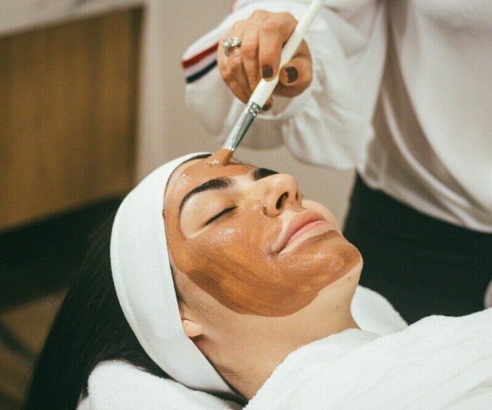 Woman applying vitamin C serum as part of a self care skincare routine