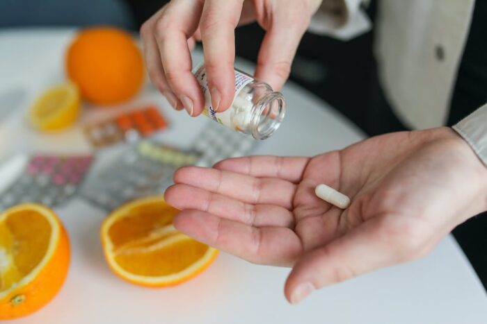 An image showing a person taking their medication, representing the importance of adherence to medication in managing Inflammatory Bowel Disease (IBD).
