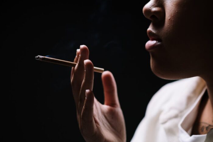 An image of a person holding a cigarette next to the text 'IBD and Smoking' to represent the topic being discussed.