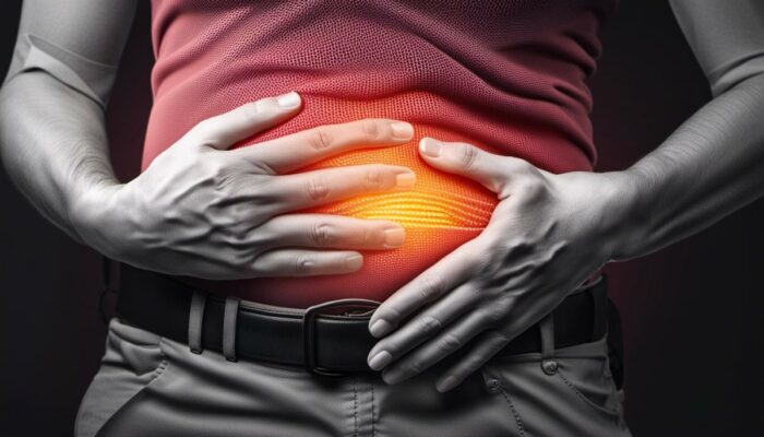 An image of a person holding their stomach in pain, symbolizing the symptoms of Crohn's disease for someone visually impaired