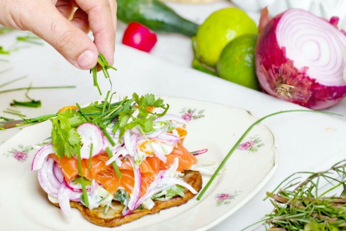 A person sitting at a table with a plate of healthy food in front of them, representing an IBD diet plan.