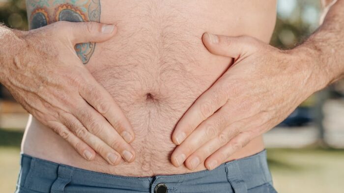 Image showing a person holding their stomach, illustrating the topic of diagnosing low stomach acid.